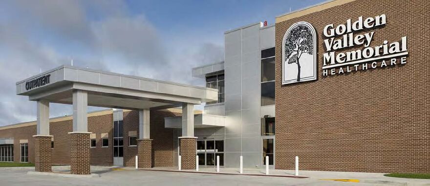 Golden Valley Memorial Healthcare building exterior under cloudy sky with outpatient entrance and brick facade.