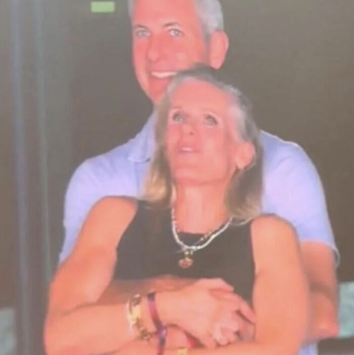 A couple embracing in dim light, highlighting the Coldplay CEO drama and questions about privacy in public spaces.