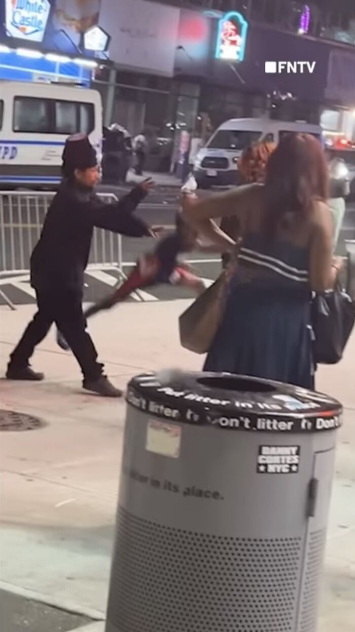 Kidnapper lifting boy at Coney Island as parents give chase during chaotic street scene at night.