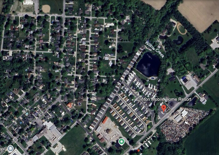 Aerial view of a crowded pool area during a swimming lesson with adults and children nearby.