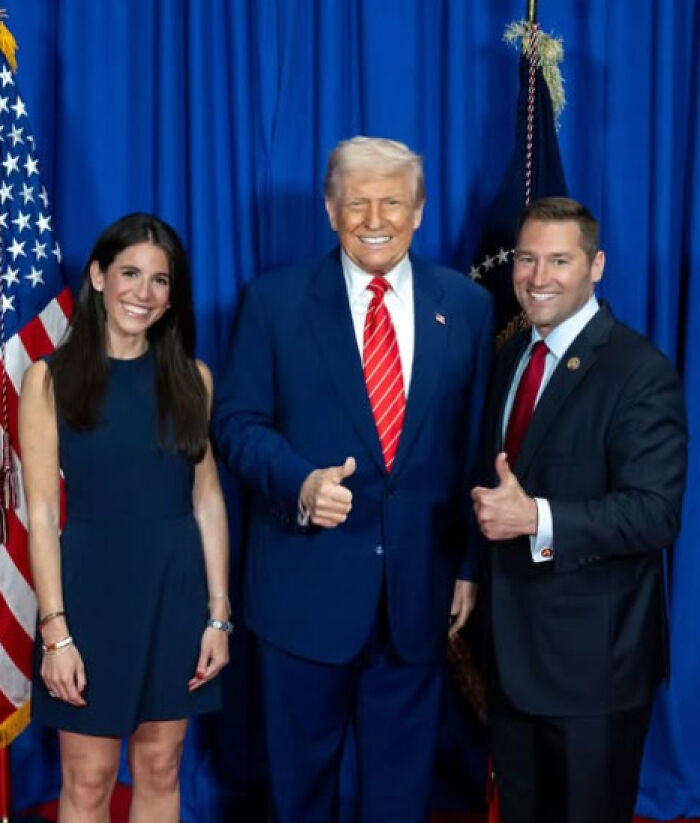 Republican lawmaker and Fox News journalist posing with former president, all smiling and giving thumbs up in front of flags.
