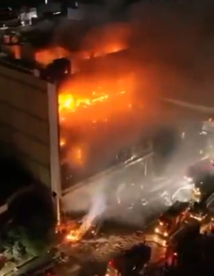 Fire engulfs Iraq shopping center after air conditioner reportedly explodes, causing major damage and emergency response at night.