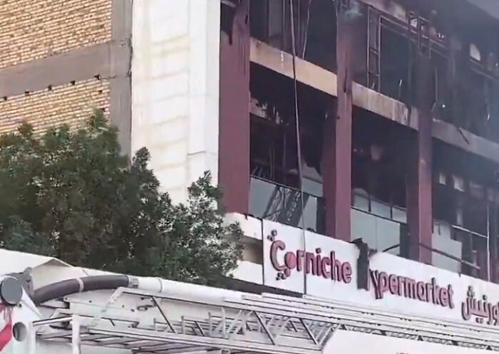Damaged exterior of Iraq shopping center with burned windows after fire reportedly caused by air conditioner explosion.