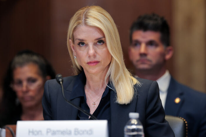 Woman in formal attire speaking at a DOJ hearing, related to James Comey&rsquo;s daughter and high-profile prosecutions.