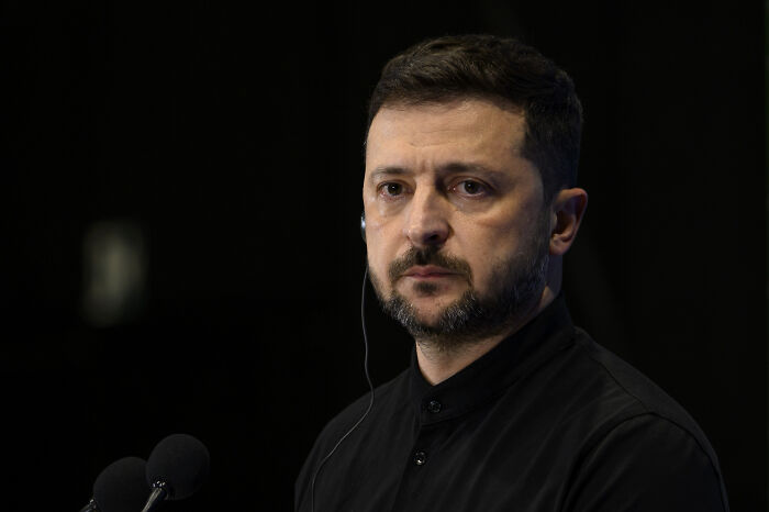 Volodymyr Zelenskyy speaking at a podium, addressing issues related to anti-corruption agencies.
