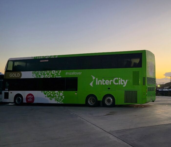Green double-decker InterCity bus parked at dusk, illustrating bus luggage compartment relevant to woman hiding toddler case.