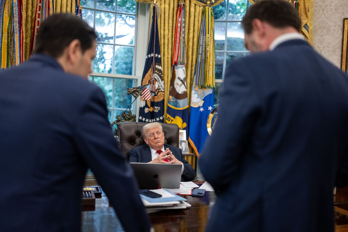 Donald Trump seated in the Oval Office during a meeting, symbolizing the Trump administration&rsquo;s political actions.