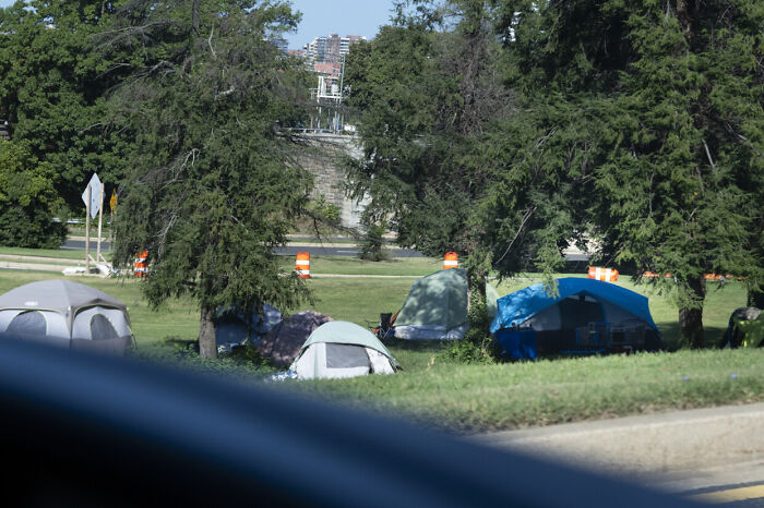 Tents set up in a green urban area, with trees and traffic cones, related to National Guard troops deployment in Washington D.C.