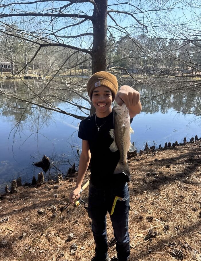 Young boy holding a fish by a lake, relating to Giovanni Pelletier family finding his body, not police involvement.