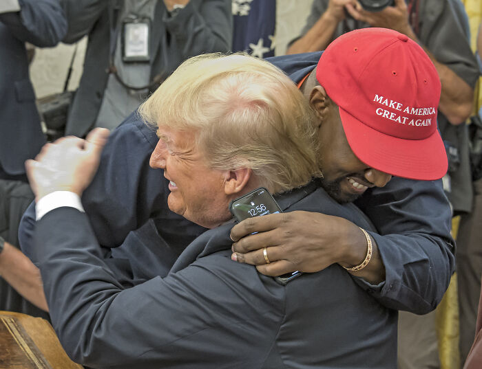 Donald Trump hugging a man wearing a Make America Great Again hat, highlighting Trump praises Sydney Sweeney Republican jeans advert.