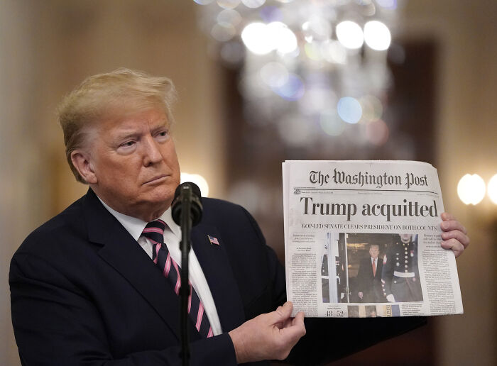 Man in suit and striped tie holding a newspaper, illustrating news about reported mortgage fraud investigation keywords.