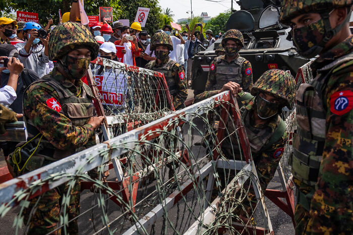 Myanmar&rsquo;s junta soldiers blocking protesters with barbed wire during tensions amid sham election allegations.