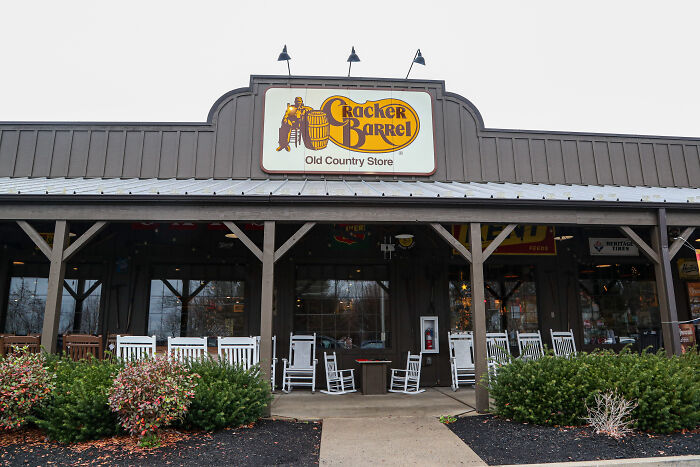 Cracker Barrel restaurant exterior with old country store sign and rocking chairs on the front porch.