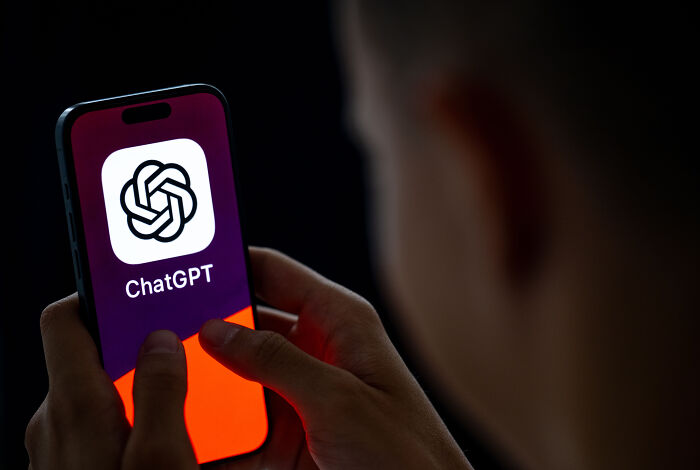 Person holding a smartphone displaying the ChatGPT logo, illustrating dangers of relying on AI therapists for teens.