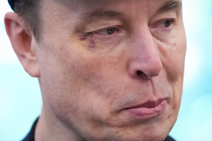 Close-up of a man wearing a dark cap, looking serious, symbolizing child exploitation economy concerns despite pledges.