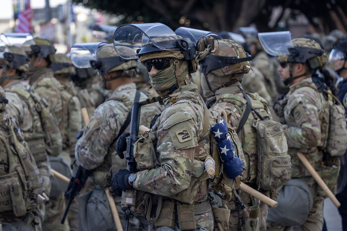 National Guard troops in full tactical gear equipped with helmets and face shields during a deployment in Washington, D.C.