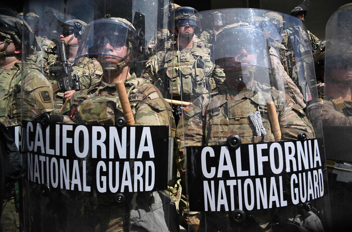California National Guard troops in riot gear with shields, part of federal takeover efforts in Washington, D.C. crime crackdown.