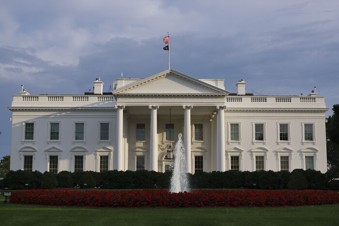 The White House with a fountain and flag, related to experts warning on Trump&rsquo;s anti-woke AI and complex LLMs.