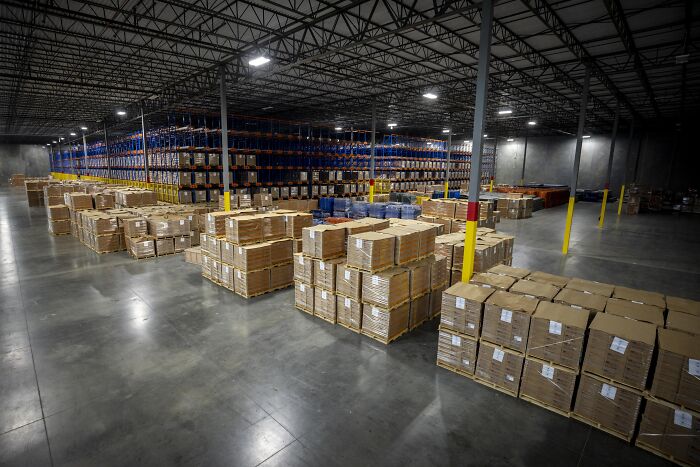 Warehouse storing large shipments of boxes symbolizing health cuts impacting women&rsquo;s reproductive rights supply chains.