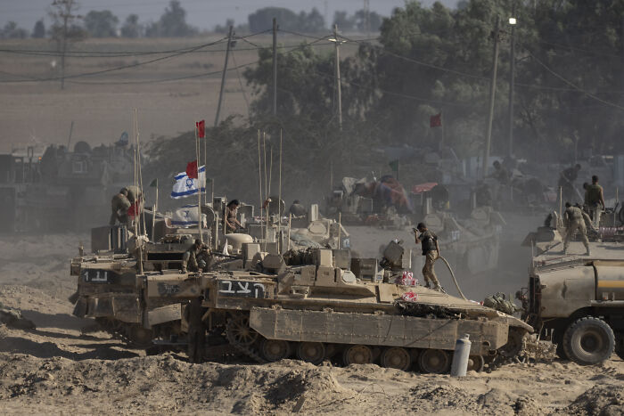 Israeli military tanks and soldiers in a dusty area, highlighting tensions amid global press freedom concerns.