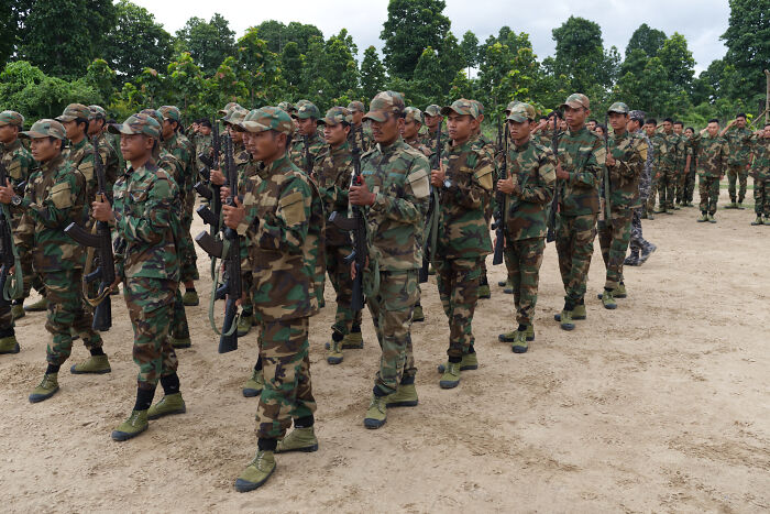 Myanmar junta soldiers in camouflage uniforms holding rifles during a military formation amid election and atrocity allegations