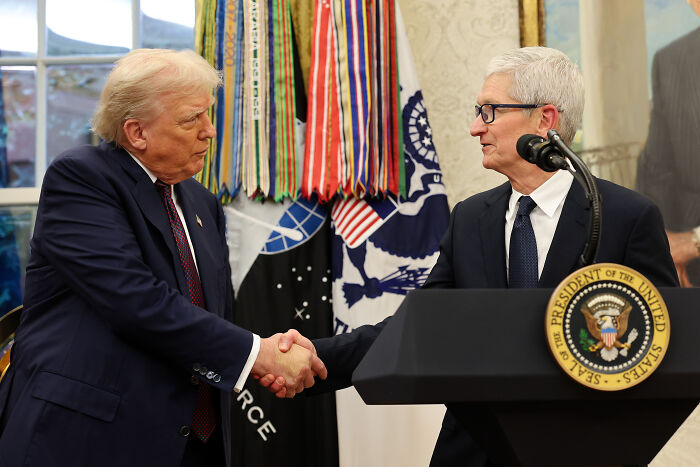 Apple&rsquo;s Tim Cook and Donald Trump shaking hands at the White House during a meeting with US presidential seal visible