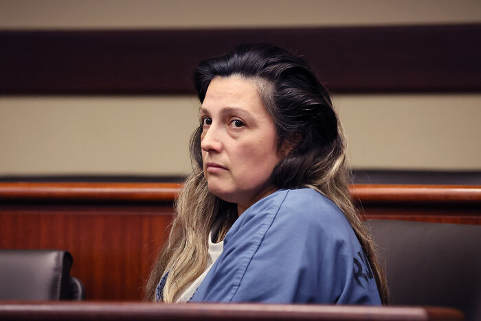 A woman in a blue prison uniform sitting in a courtroom, related to Emmanuel Haro&rsquo;s dad confession case.