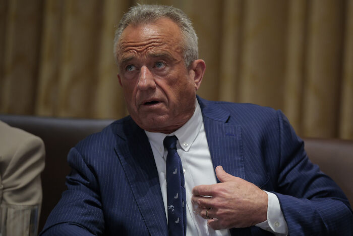 Man in a blue suit discussing CDC leaders resigning with dire warning over perilous RFK Jr health plans in a formal setting