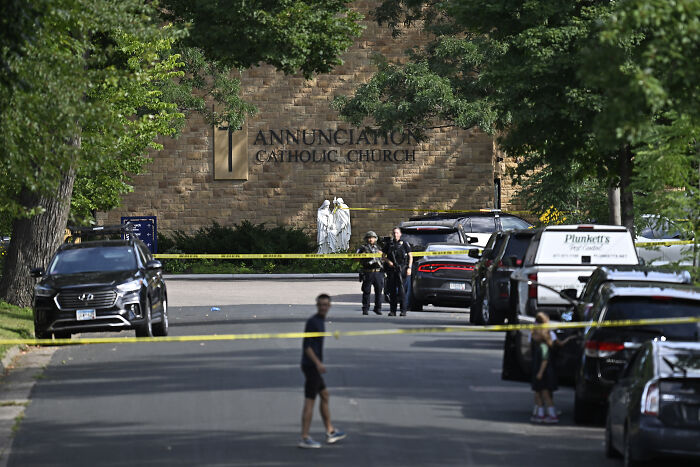 Police tape blocks street near Annunciation Catholic Church as officers investigate Minneapolis school tragedy site.