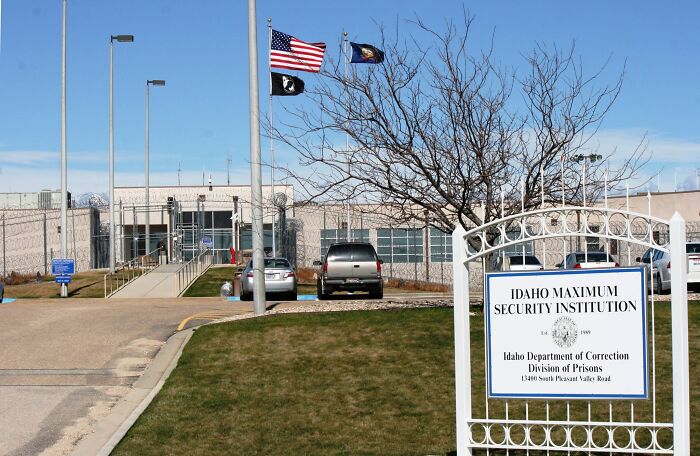 Idaho Maximum Security Institution entrance with flags, related to inmates plotting prison harassment against Bryan Kohberger.