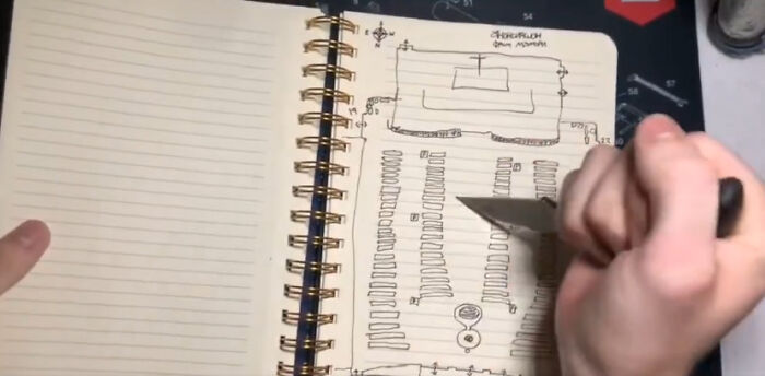 Hand drawing a detailed sketch inside a notebook, illustrating a Minneapolis school tragedy scene by 5th grader.