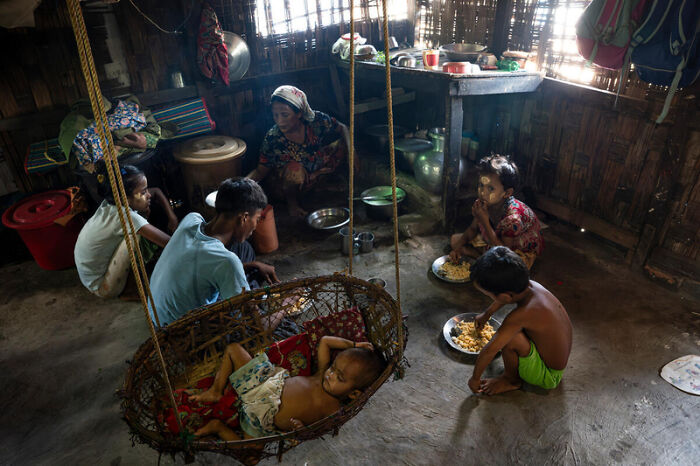 Family inside a wooden home in Myanmar, highlighting the impact of junta&rsquo;s sham election amid atrocity allegations.