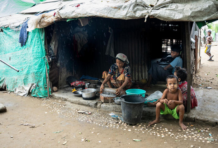 Myanmar junta carrying out sham election amid shocking atrocity allegations, image shows family in rural setting with minimal shelter.