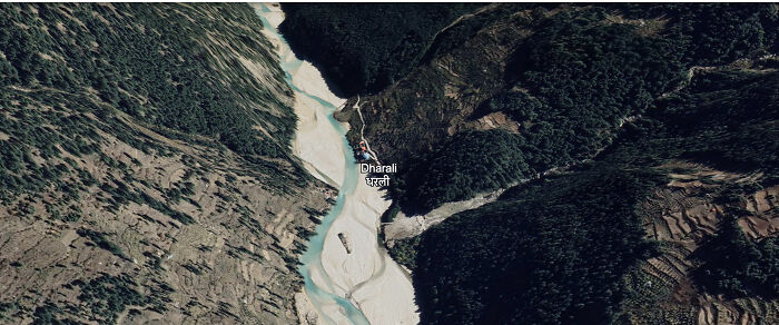 Aerial view of a town near a river in a mountainous area vulnerable to severe flash floods sweeping the area away.