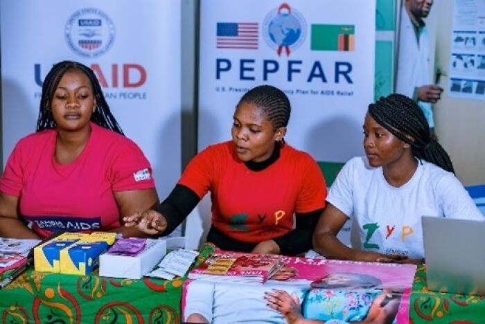 Three women at a health outreach table promoting reproductive rights and access to reproductive health resources in the U.S. and abroad.
