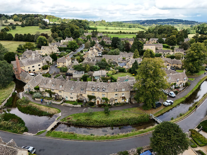 Aerial view of a village with stone houses and greenery, illustrating villagers&rsquo; fury over convoy parking at grocery store.