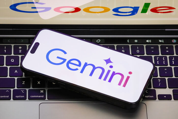 Smartphone displaying Gemini logo on laptop keyboard, illustrating dangers of relying on AI therapists in teen's final moments.