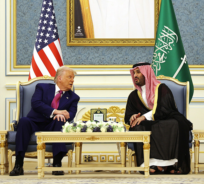 Two leaders discuss global politics in a formal setting with US and Saudi flags, reflecting Brics dollar and shifting global order.