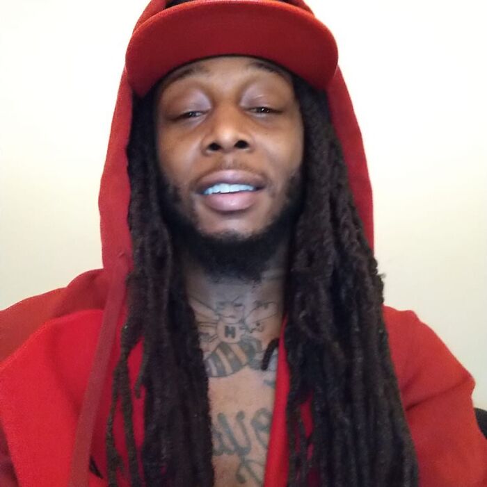 Man with long dreadlocks wearing a red hoodie and cap, smiling indoors, related to crimes that shocked the nation in 2025.