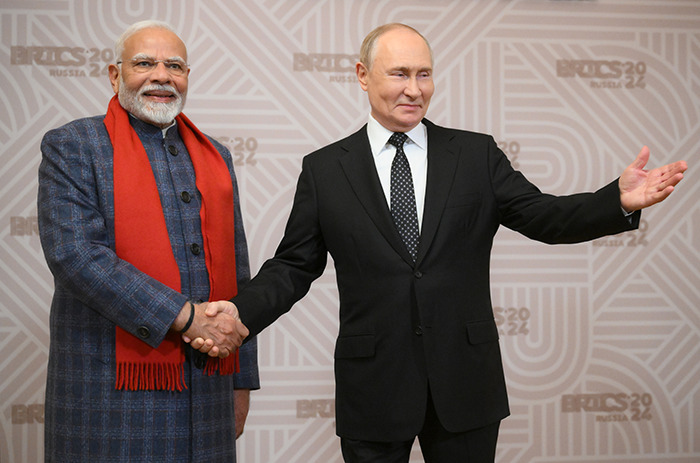 Two leaders shaking hands at BRICS 2024 summit, symbolizing BRICS, dollar influence, and shifting global order.