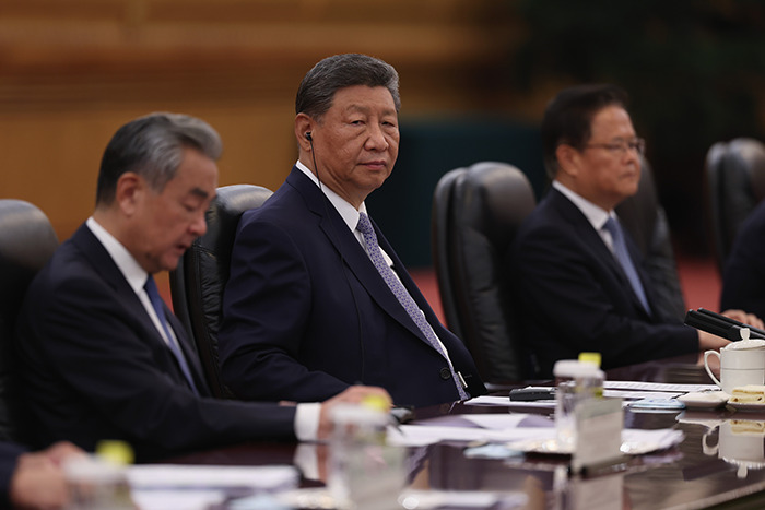 Chinese officials in suits seated at a conference table during a meeting discussing Brics and the shifting global order.