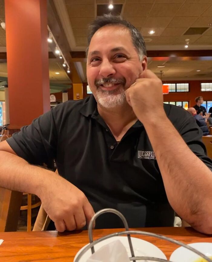 Man smiling in a restaurant, representing New Hampshire Country Club shooting victim who protected family from gunman.