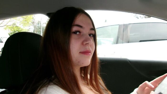 College student with a serious expression sitting in a car, highlighting tragedy after harassment by ex-boyfriend.