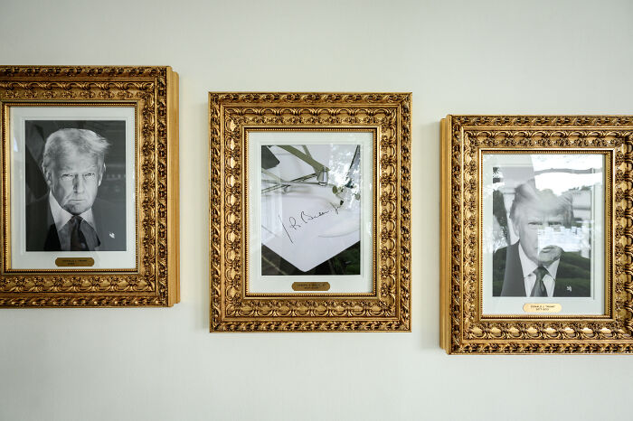 Three ornate framed portraits with a signed document, highlighting the White House presidential walk of fame display.