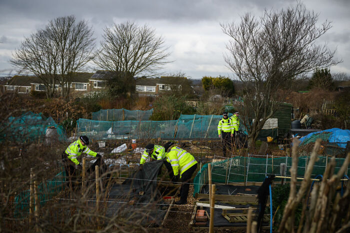 Police officers in high-visibility jackets investigating an outdoor area linked to Aristocrat Constance Marten neglect case.