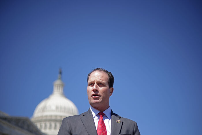 Politician speaking outdoors near U.S. Capitol, representing slain activist Charlie Kirk in GOP proposal for currency appearance.
