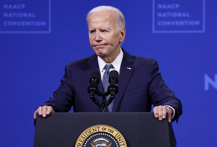 President Biden speaking at a podium during NAACP National Convention with White House Presidential Walk Of Fame context.