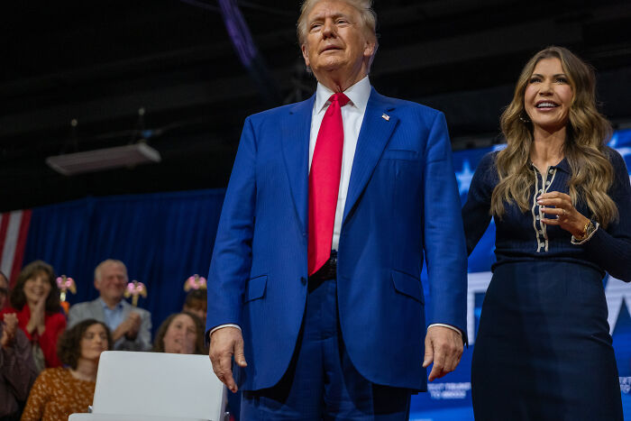 Donald Trump and a woman standing at an event, related to Trump camp weighing in on Kristi ICE Barbie Noem affair claims.