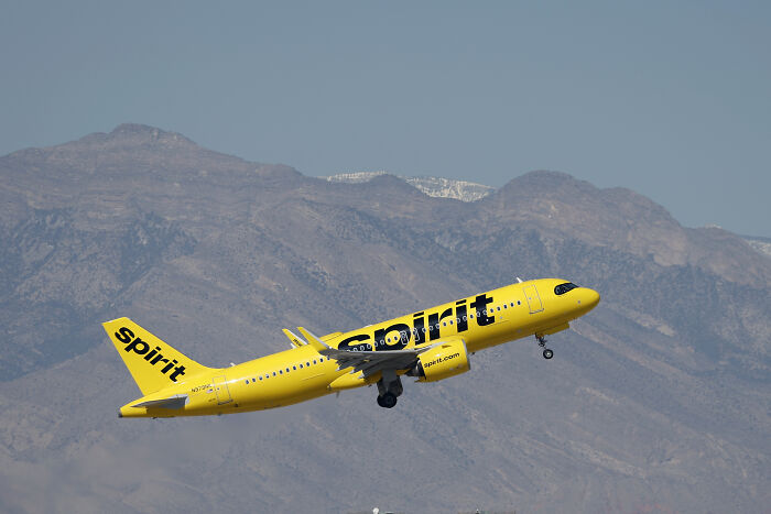 Spirit Airlines plane ascending with mountainous background, related to Spirit pilots flying too close to Air Force One.