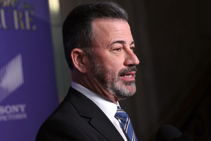Jimmy Kimmel in a suit and striped tie speaking into a microphone during an on-air response segment.